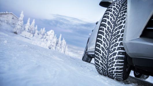 Vehicle with studded tires on winter road
