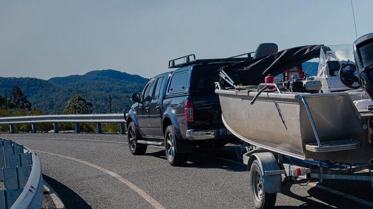 Truck on road pulling boat trailer