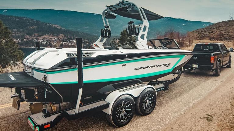Are your recreational trailer tires road-ready? Truck pulling boat trailer on gravel road