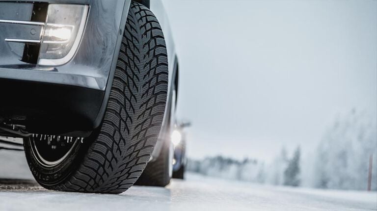 Vehicle displaying best winter tire and best snow tire on winter road