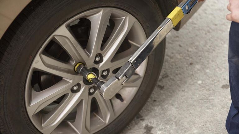 Kal Tire team member with torque wrench on tire