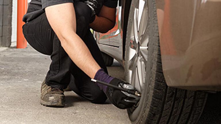 checking air pressure with tire gauge