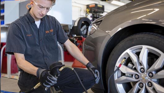 Kal Tire team member checking tire pressure