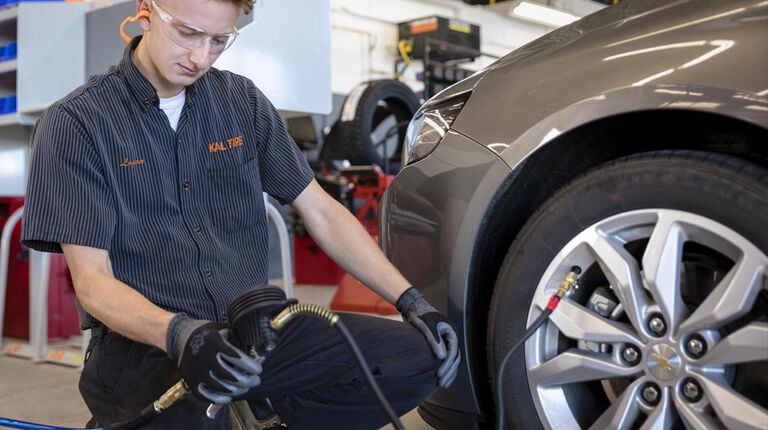 Kal Tire team member checking tire pressure