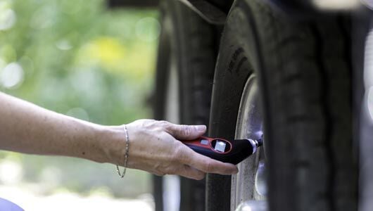 Checking tire pressure on a trailer tire