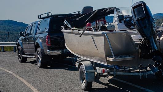 Truck pulling a boat trailer on highway