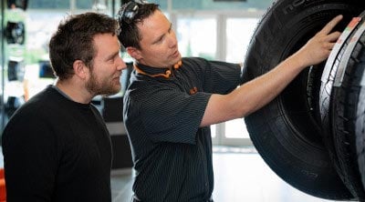 Team member and customer discussing tires