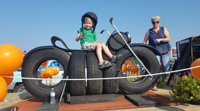 child riding on recycled tire bike toy