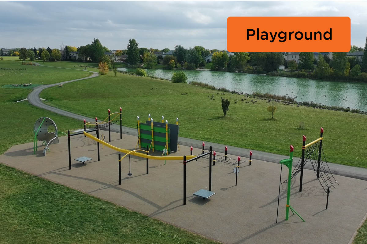 Outdoor exercise space with durable recycled rubber surfacing with recycled rubber pathways and a lake in the scenery.