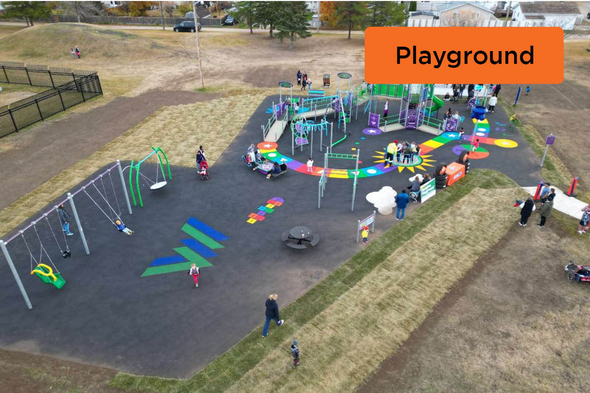 An aerial image of a large playground with colourful recycled rubber ground, play games and play equipment.