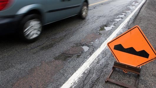 Vehicle driving by a road bump sign